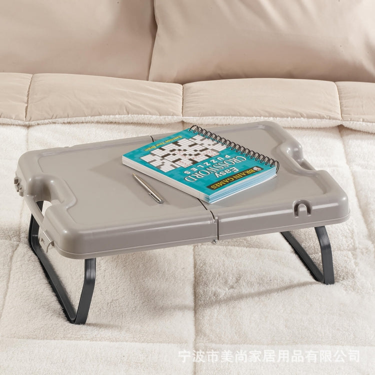 Folding tray table with legs, light gray top with notebook and pen