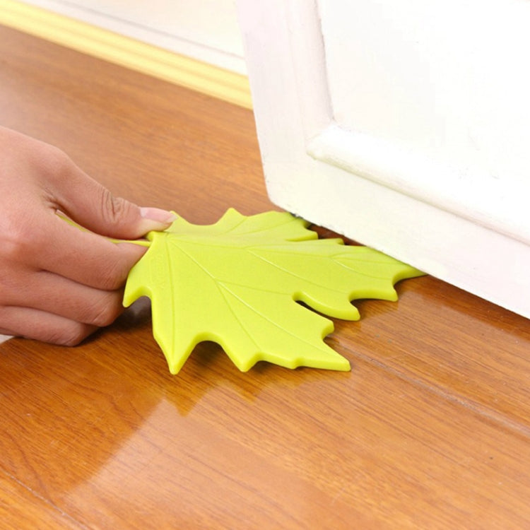 Lime green maple-leaf finger safety door stop holding a door open