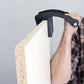 Black wood board clip secured on board edge with gray handle and metal knob