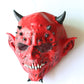Red demon monster latex mask with open grin, black eyes, and horned head