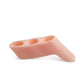 Three-hole thumb separator pad, translucent orange, angled view with three openings