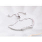 Silver bow stretch bracelet with heart-shaped sparkle charm and bead clasp