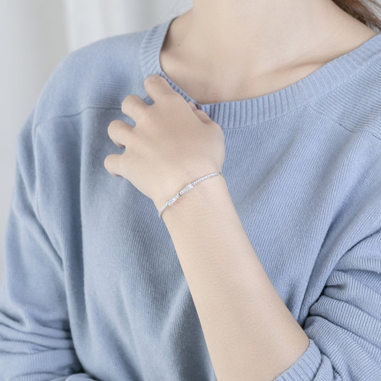 Silver bracelet with bow and small bead accents worn on wrist