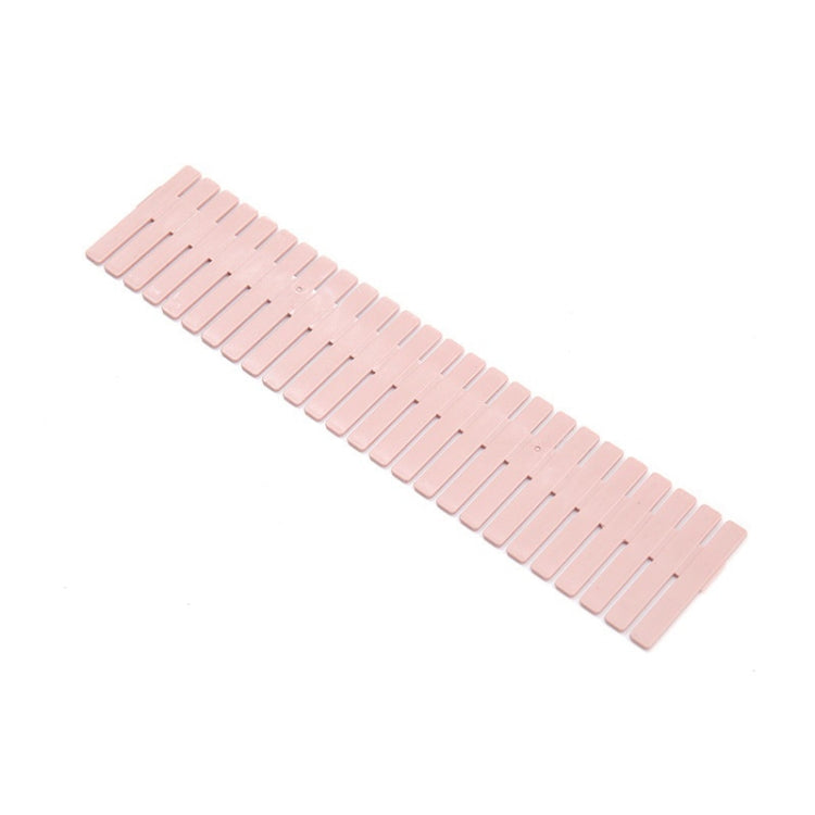 Pink plastic drawer divider strip with evenly spaced slots, long storage insert