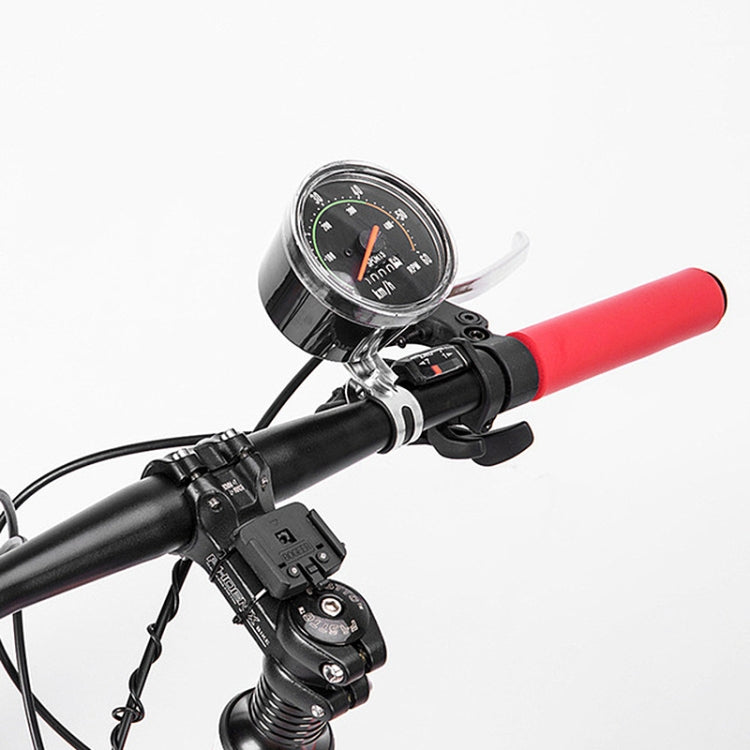 Round mechanical bicycle speedometer installed on handlebar near control switches