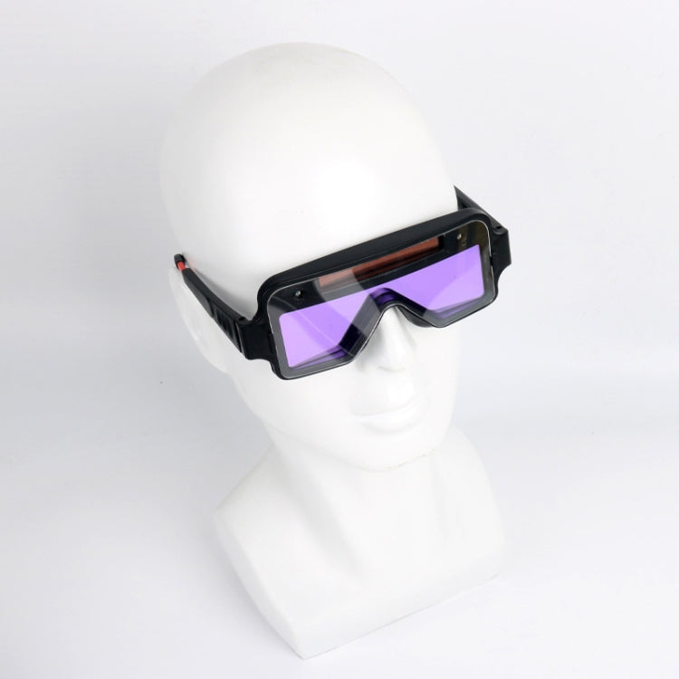Welding safety goggles on white mannequin head, black frame with purple tinted lens