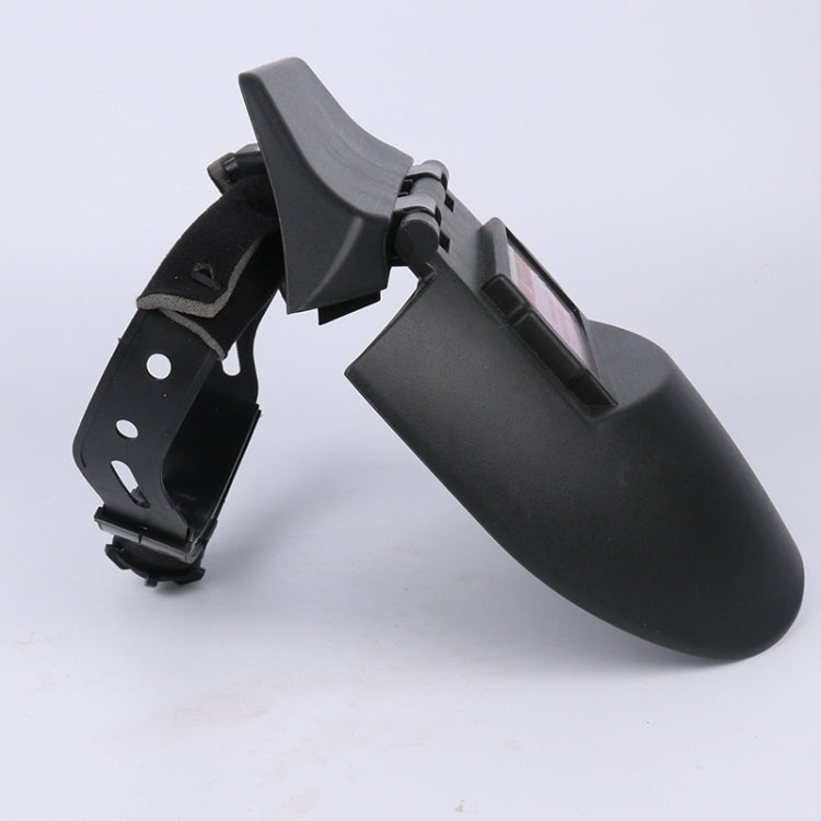 Welding protective helmet with attached strap and dark flip-up face shield