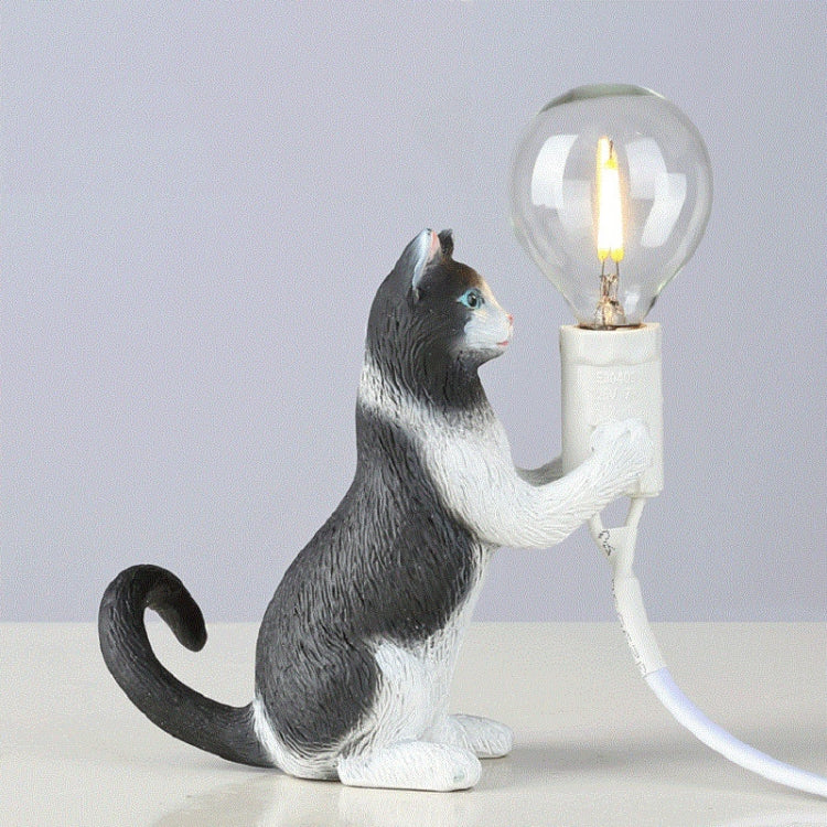 Cat figurine mini night light table lamp with glowing bulb, seated with raised paw, gray and white