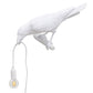 White bird wall lamp figurine with hanging bulb and exposed wire cord