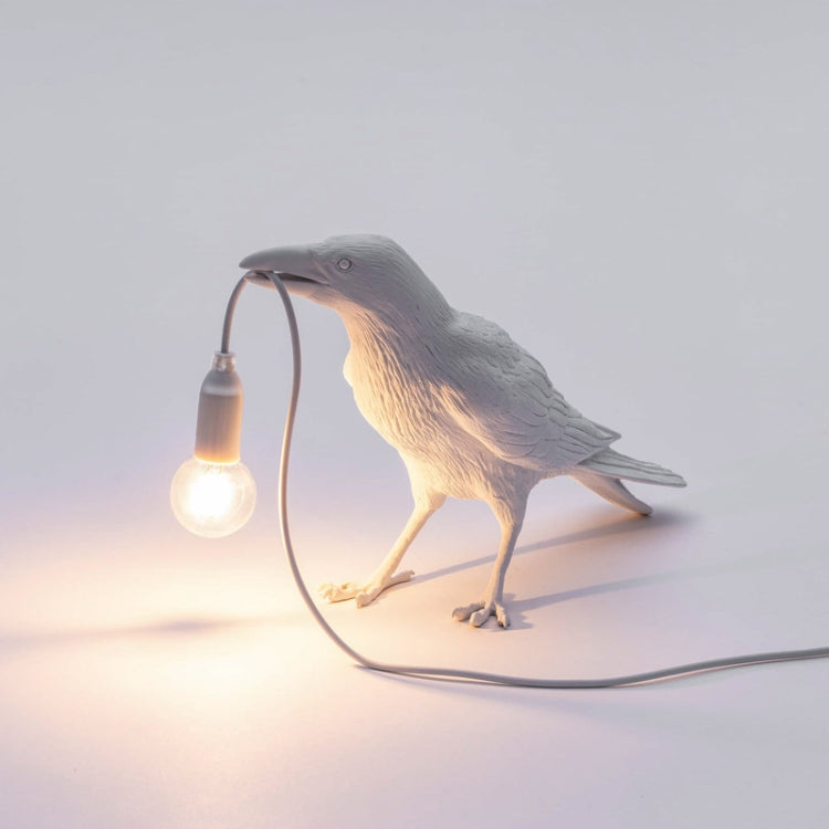 White bird table lamp with lit E14 bulb and curved cable