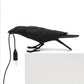 Black resin bird table lamp with hanging bulb and dark cord, perched on white base