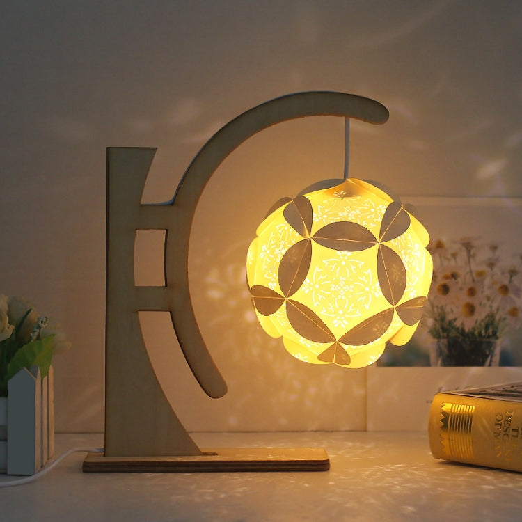 Paper carving shadow lamp with arc stand, yellow geometric paper shade glowing