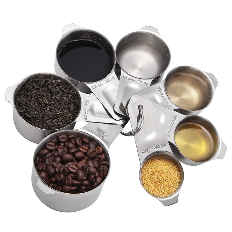 Stainless steel measuring cup set filled with assorted dry ingredients; loop handles