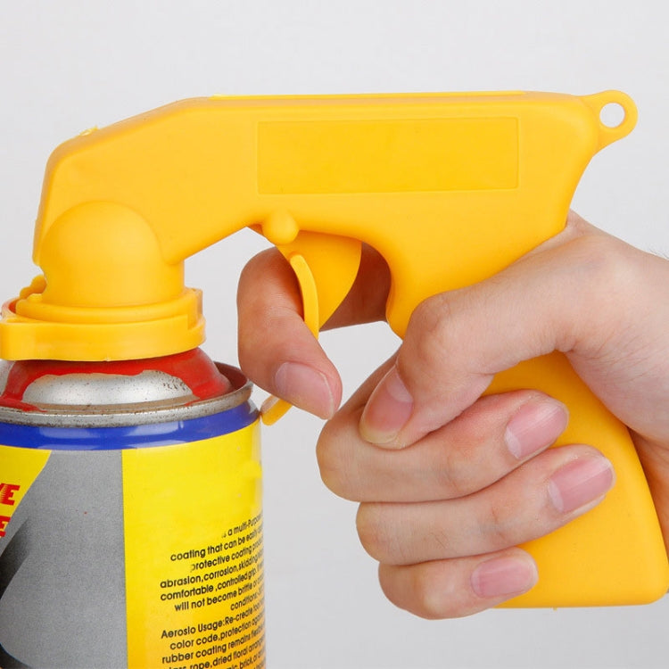 Yellow spray adaptor paint gun clamp attaching to an aerosol can; hand holding
