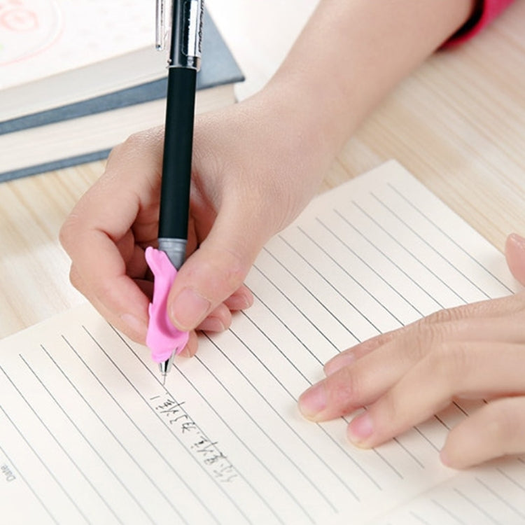 Pink dolphin-shaped writing pen held by hand over lined notebook paper