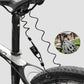 Black coiled cable helmet lock mounted on a bike frame with combination keypad
