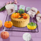 Silicone pumpkin cake mold with 3D jack-o-lantern cavities, white mold blocks