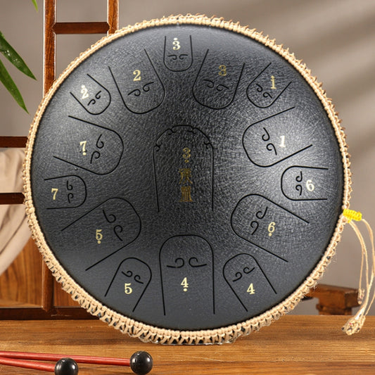 Dark gray steel tongue drum with etched tone symbols and braided rope rim