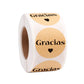 Round Gracias label stickers on a roll, kraft beige background with heart icons