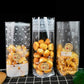 Three clear treat bags with baked with love label stickers and snack contents