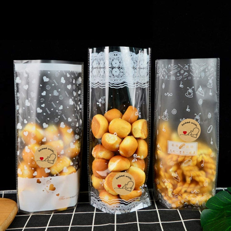 Three clear treat bags with baked with love label stickers and snack contents