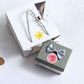 Gift boxes with small round yellow sun thank-you sticker on tied tags