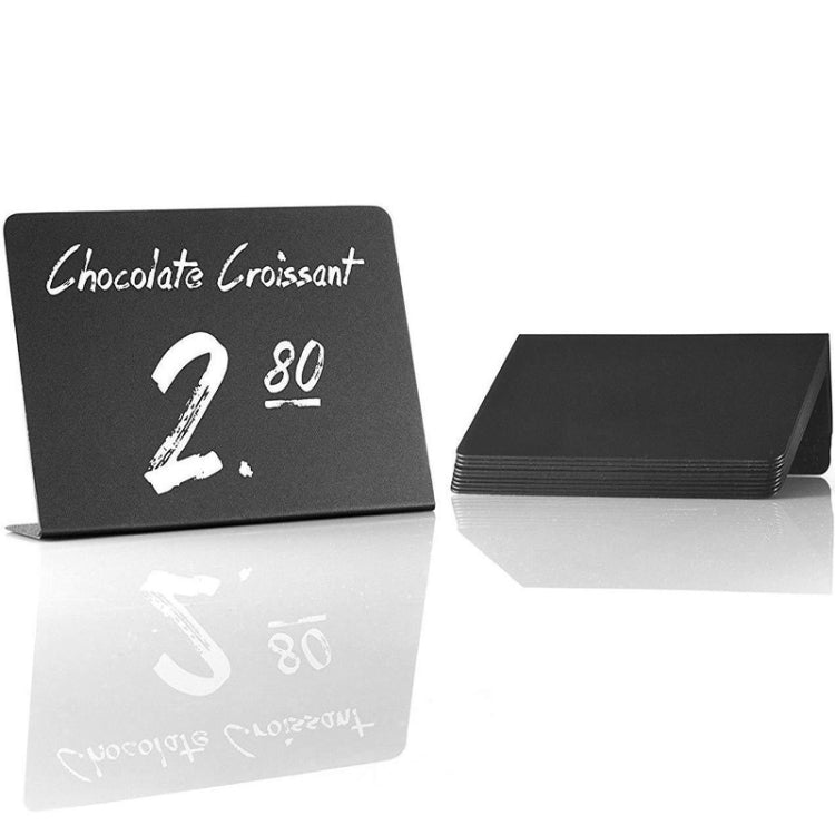 Black desktop sign with white writing; plus stacked boards on a reflective surface