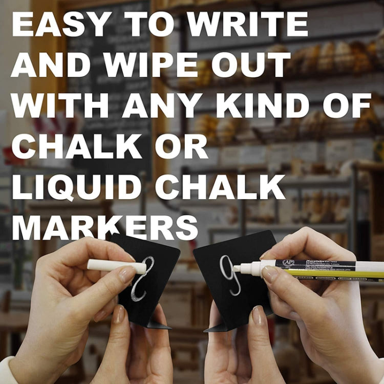 Hands writing on a small black tabletop chalkboard with a marker, ready to wipe