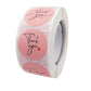 Close-up of thank you baking sticker roll with pink round labels and heart accents