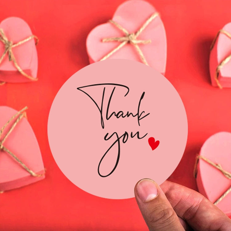 Handheld round thank you sticker with pink script and small red heart