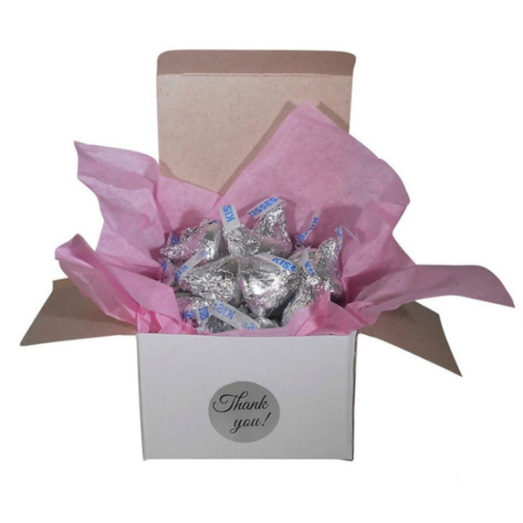 Thank-you sticker on a gift box with pink tissue and wrapped treats