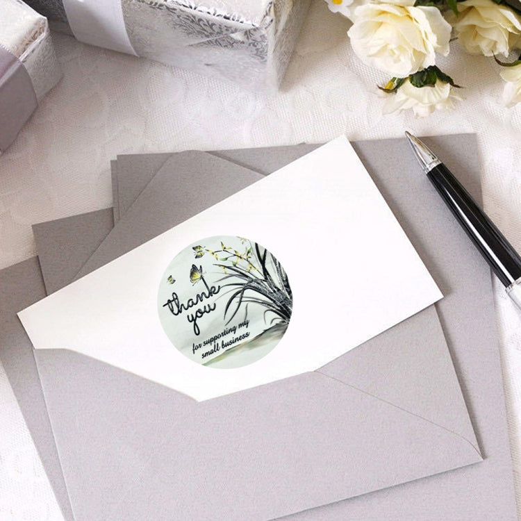 Round thank-you sticker sealing a white envelope with floral branch and butterflies