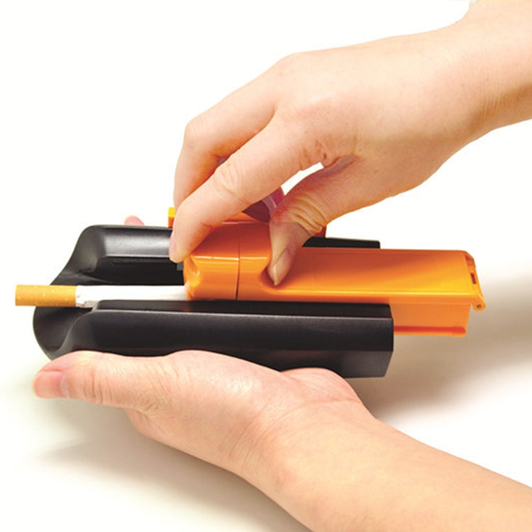 Manual cigarette making machine held by hands, with orange top and cigarette tube