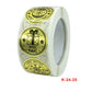 Christmas sticker label roll showing gold circular “Merry Christmas” designs and K-24-25