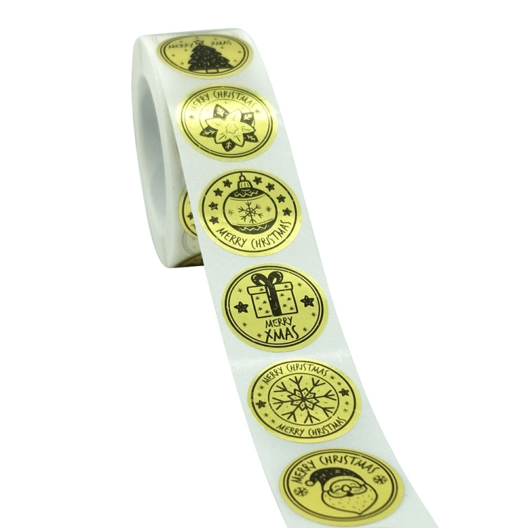 Strip of gold Christmas sticker labels on a roll, with circular “Merry Christmas” designs