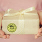 Gift box with a gold circular “Merry Christmas” sticker label