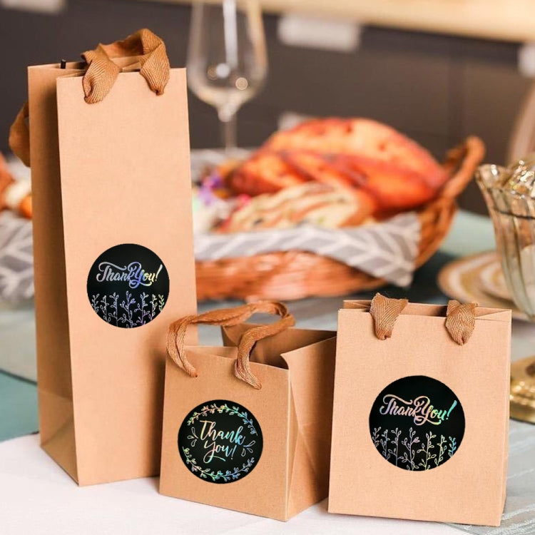 Round 'Thank you' stickers on brown gift bags and wrap, black circles with floral ring