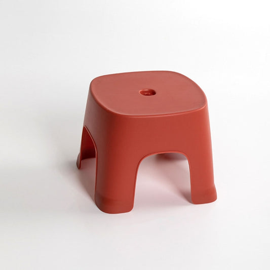 Red plastic low step stool with side cutouts and round top hole
