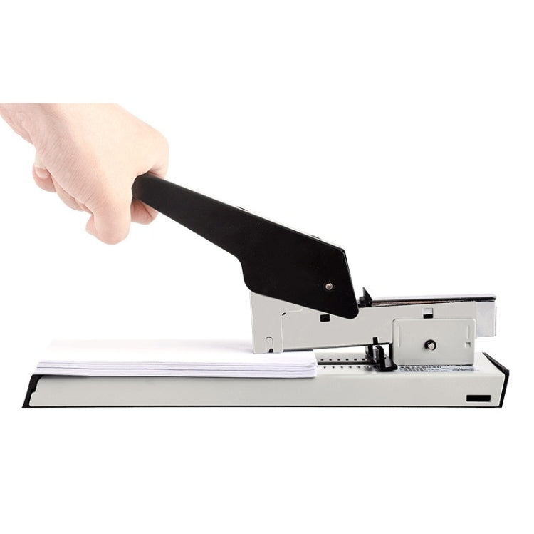 Manual stapler positioned on a stack of papers, black lever ready to staple