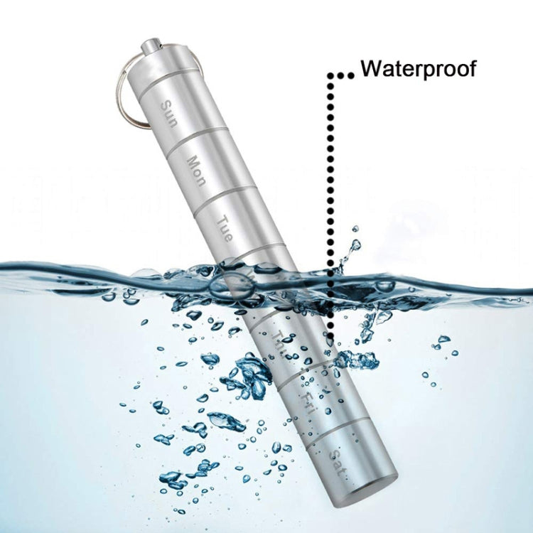 Aluminum waterproof 7-day pill organizer tube with key ring above water splashes