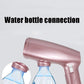 Rose-pink mini handheld garment steamer showing water bottle connection area