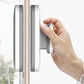 Double-sided magnetic window wiper with gray handles, shown on window edge with hand