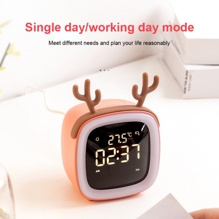 Coral red deer-shaped LED alarm clock on bedside surface with bright time display
