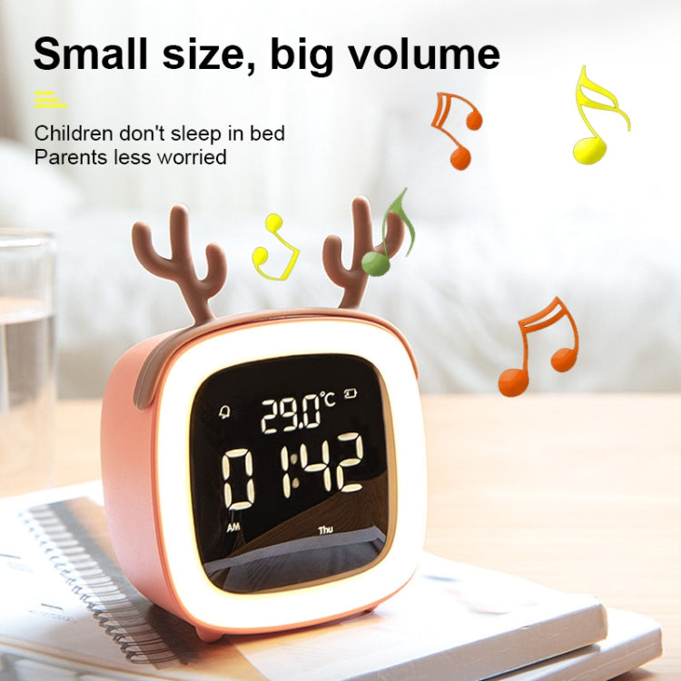 Orange deer-shaped LED alarm clock with glowing ring and time display on desk