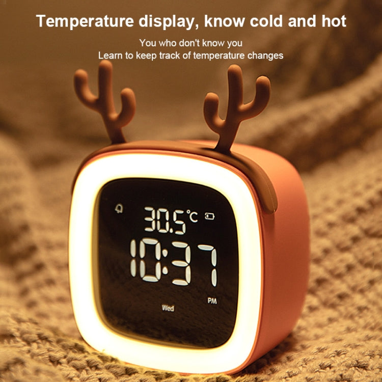 Orange deer-shaped LED alarm clock close-up with bright backlit screen and antlers