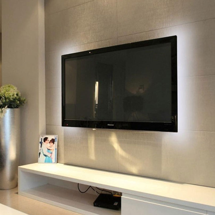 USB LED strip light producing a warm white glow along a wall-mounted TV
