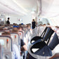Black foot rest hammock clipped to an airplane seat for resting feet