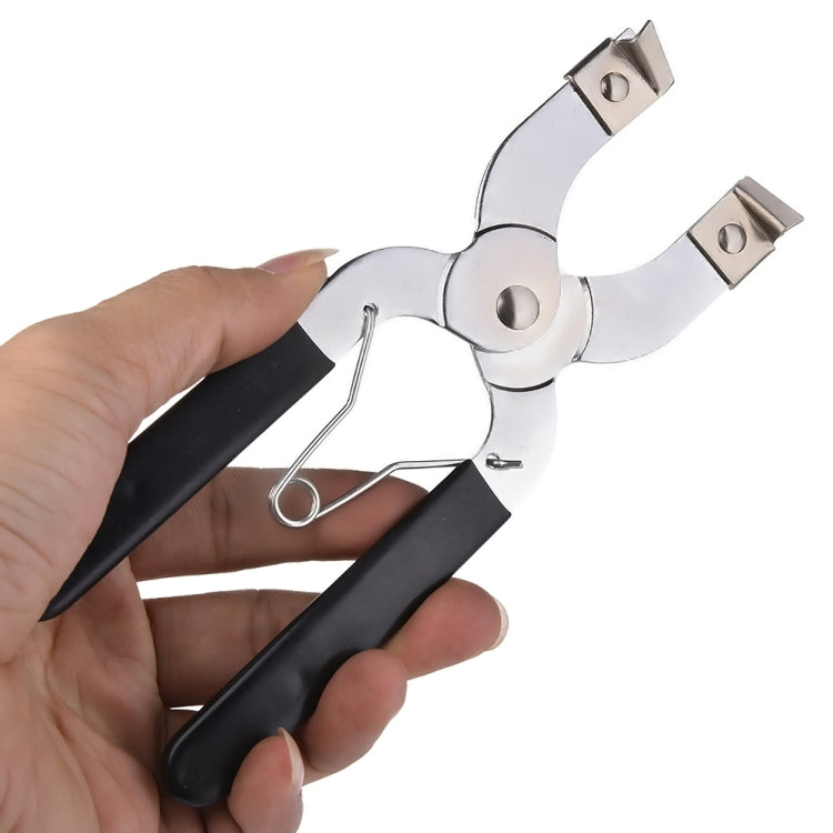Ring installer pliers held in hand, black grips and silver jaw expander