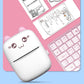 White cat mini thermal printer with paper emerging, near keyboard and document sheets