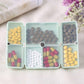 Folding portable pill box opened, 6 compartments with assorted colored tablets